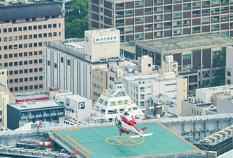 着陸する様子。ヘリの先には旧市庁舎が見える（横浜ランドマークタワー「スカイガーデン」で撮影）