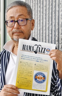 ロゴを紹介する協会誌を手にする中川理事長