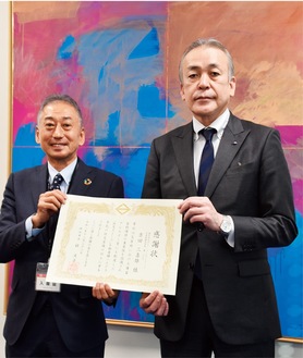 平原副市長から感謝状を受け取る同社の吉田会長（左）