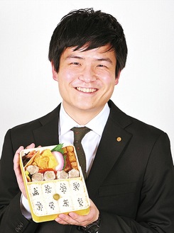 同社不動の一番人気「シウマイ弁当」を掲げる山崎さん