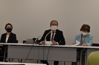 会見で説明する市民の会世話人の岡田弁護士（中央）