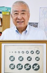 県警のシンボルマークを手に伊藤さん。退職後は地元で柔道場を開き、自身は8段。防犯教室なども行っている