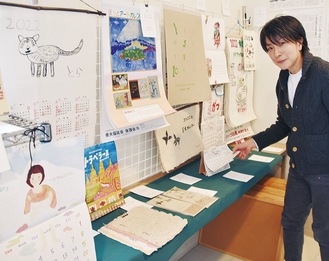 生活創造空間にしに展示されているカレンダー。右は担当する世織書房の門松さん