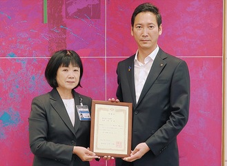横浜市の大久保智子副市長（左）から感謝状を受け取る商議所の森健二専務理事