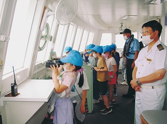 操舵室から横浜の街を双眼鏡で覗く子どもたち