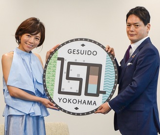山中市長（右）から釈さんに１５０年のロゴがデザインされたマンホールレプリカが贈られた