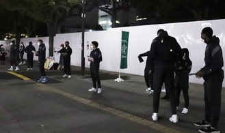 関内駅前で歩行者にチラシを配る選手たち