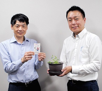 カードと店で育てている鉢を持つ担当者