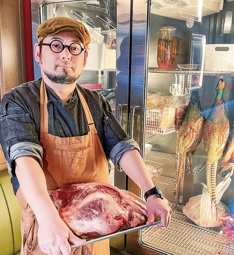 取材に応じてくれたビストロ｢Ａmi｣の佐久間シェフ。店内にある熟成庫の前でシカ肉を手に