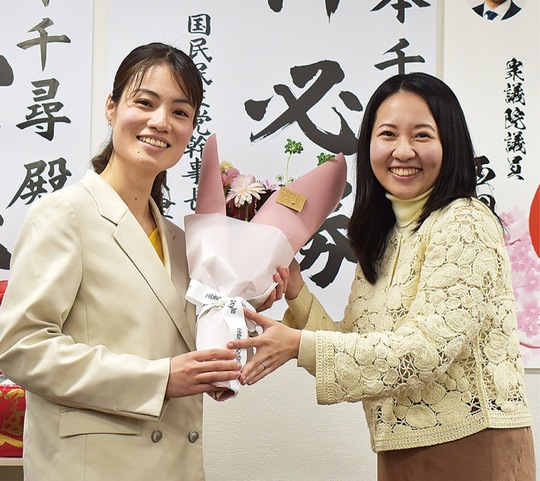 深作祐衣市議から花束を受け取る熊本氏（左）
