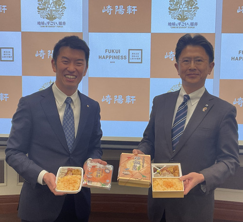 「ふくい名水サーモン炒飯弁当」（左・冷凍タイプ／右・通常タイプ）を手にする野並社長（左）と福井県東京事務所の萩原雅広所長