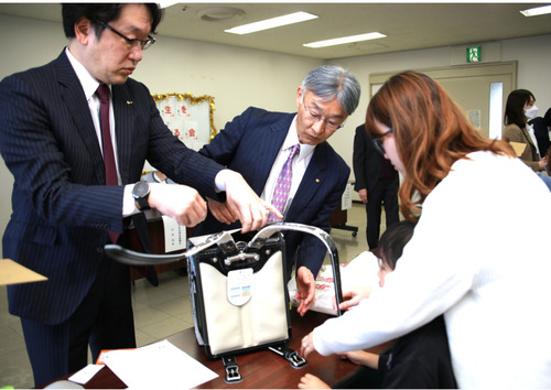 親子とランドセルの肩ベルトを調整する西ＲＣの長谷川会長（中央）とMM21ＲＣの亀田会長（左）