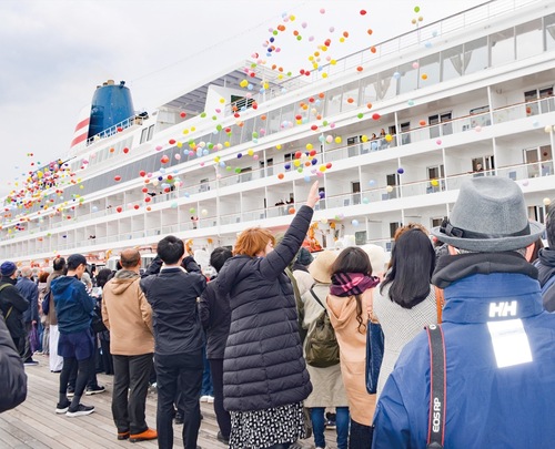 手を振り出港を見送る人々