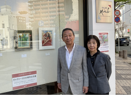 特徴的なショーウィンドウの前に立つ今井夫妻