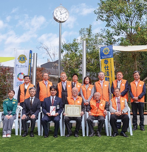 時計塔の前で式典に出席したクラブメンバーと関係者ら