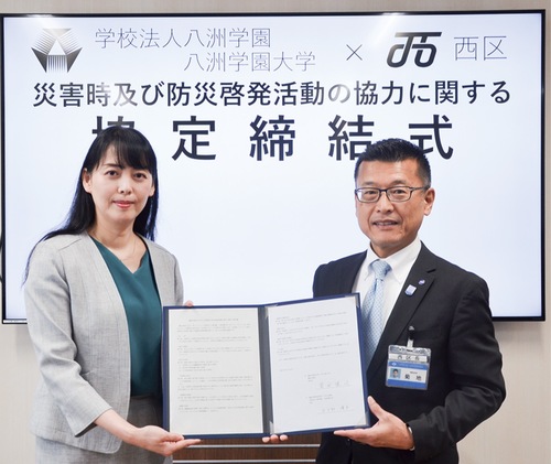 協定書を手にする菊地区長（右）と水戸部学長