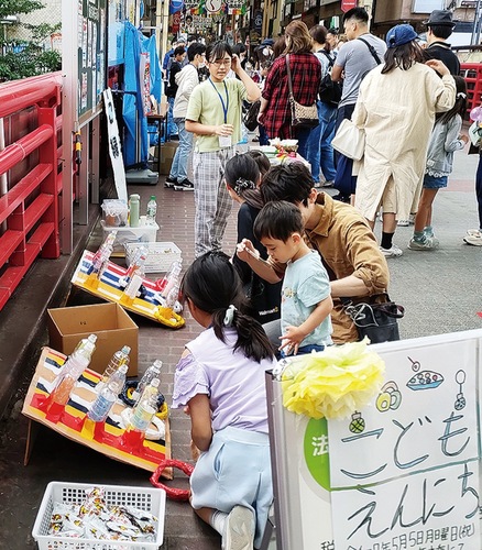 小学生の運営のもと、輪投げを楽しむ来場者