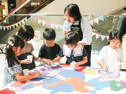 アップサイクルの絵の具で色を塗る子どもたち