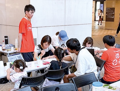 紙コップロケットを作る子どもたち