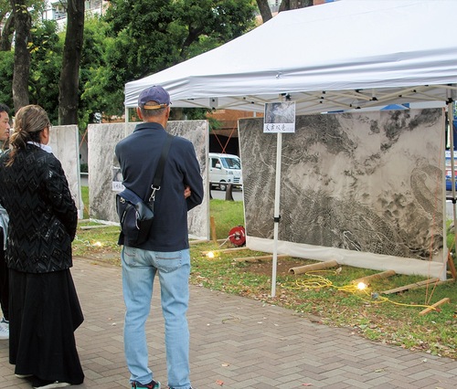 朝倉さん（左）の解説を聞きながら作品を鑑賞する来場者