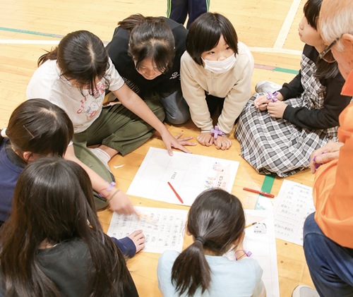 地域住民と備蓄品を選ぶ児童
