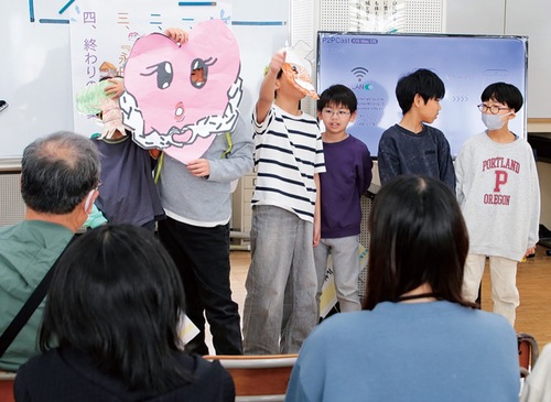 住民らにゲームを紹介する児童（３月18日）