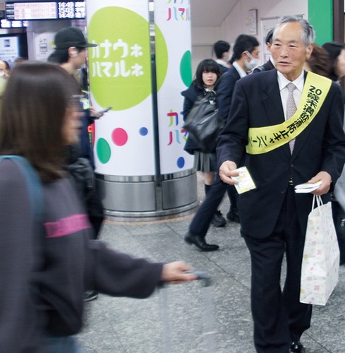 ティッシュを通行人に手渡す佐藤会長