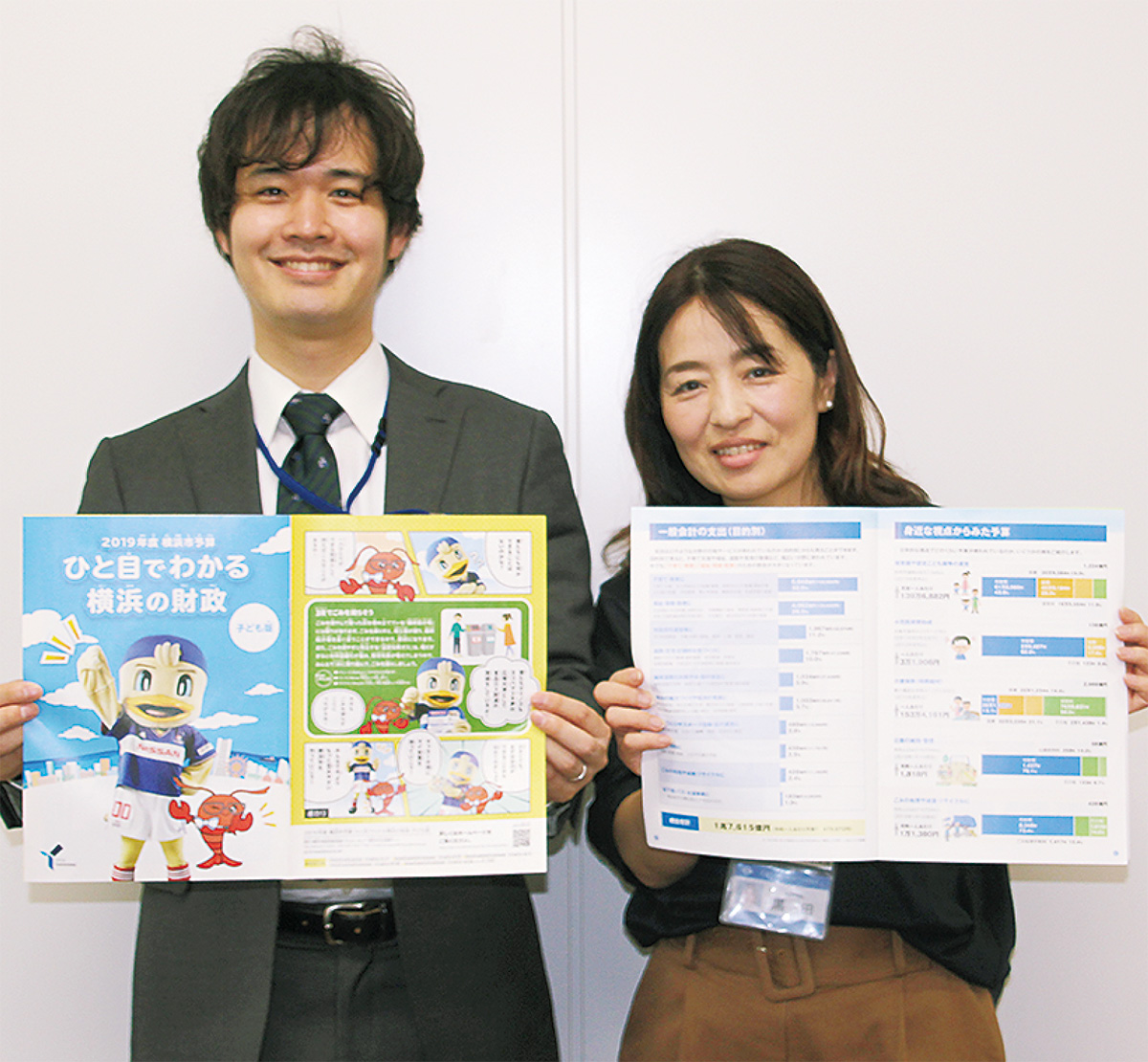 新冊子を持つ市財政課職員