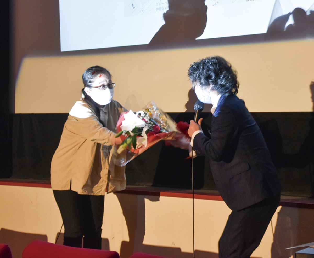 同じミニシアター、横浜シネマリンの八幡温子支配人から花束を受け取る梶原支配人(右)