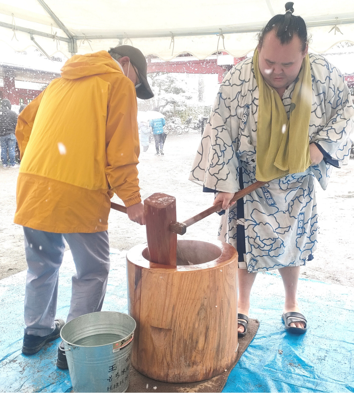 雪の中、餅をつく御室岳さん（右）