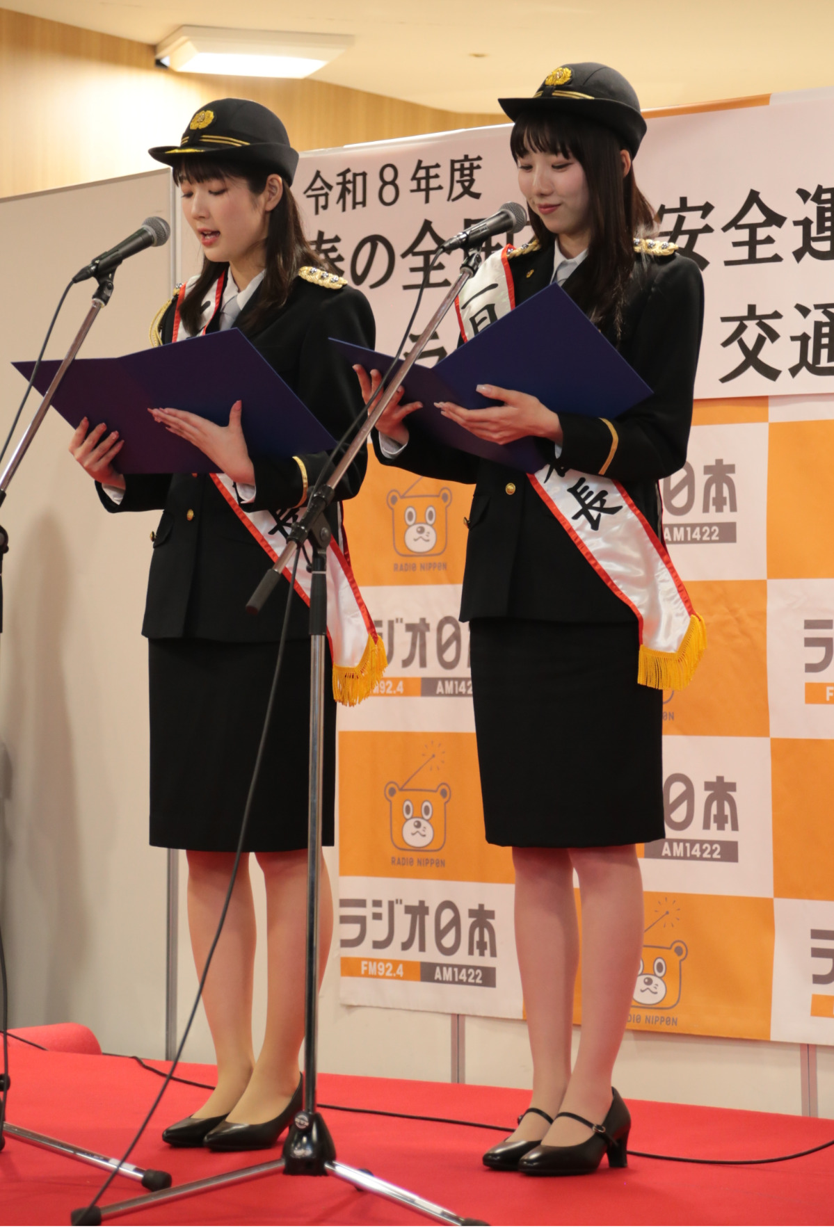 セレモニーで交通安全宣言を読み上げる山本さん（左）と宇佐美さん