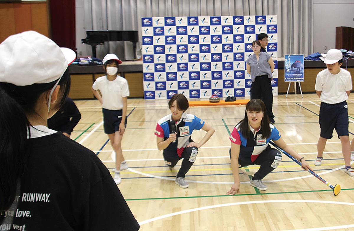 ストーンの投げ方を指導する小谷選手(右)と吉村選手