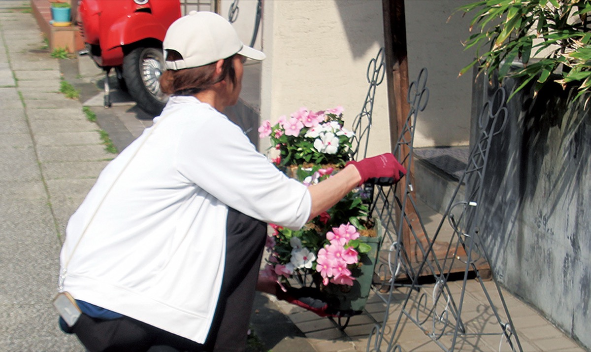 店舗前に花バスケットを飾る参加者