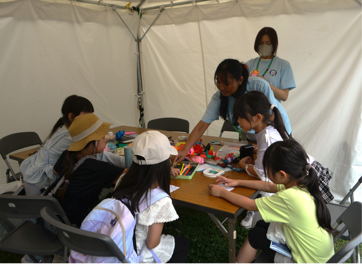 子どもたちにワークショップを行う横浜デザイン学院の留学生