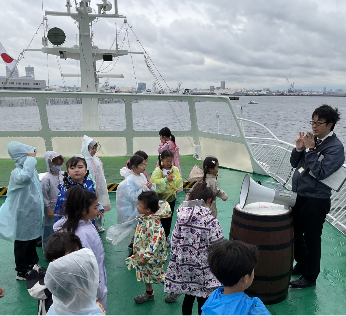 実際の港湾施設を見ながら「船から荷物を積み降ろしするガントリークレーンは『赤いキリン』と言われています」と説明する同協会総務課長の佐藤恒さん（右）