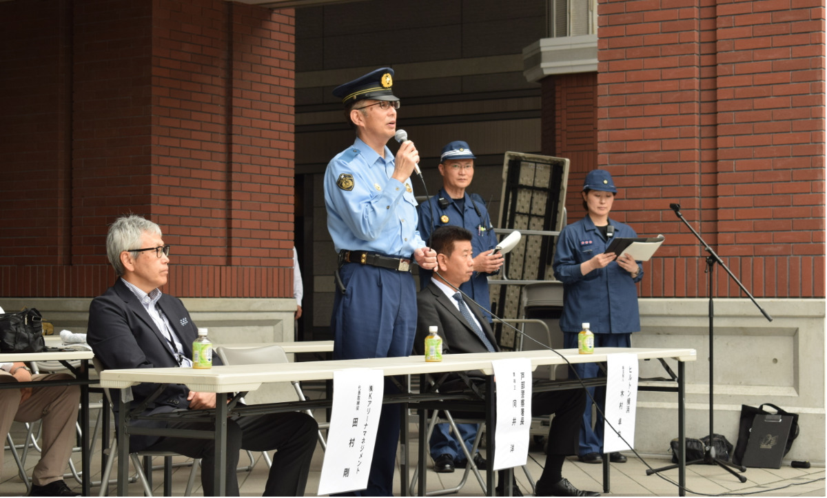 訓練の講評を述べる戸部警察署の向井洋署長(写真中央)とKアリーナマネジメントの田村剛代表取締役社長(左)、ヒルトン横浜の木村卓也総支配人(右)