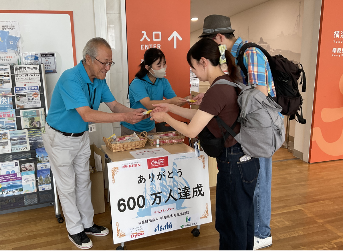 企業が協賛した記念の品を受け取る観覧者