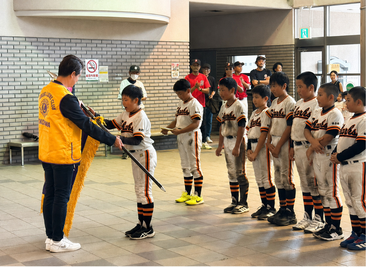 ライオンズクラブのメンバーから選手に優勝旗が手渡された
