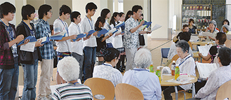 唱歌を合唱する生徒と地元住民