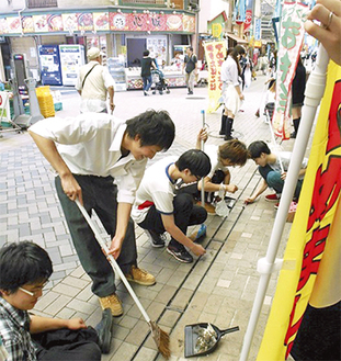 弘明寺商店街を清掃する生徒（写真提供・同校）
