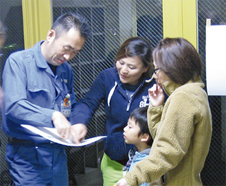 中村小で区職員（左）から説明を受ける住民