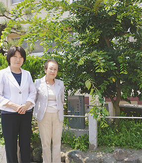 エノキの前に立つ伊藤校長（左）と長崎和枝さん