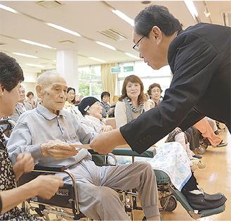 中島区長（右）から記念品を受け取る田中さん