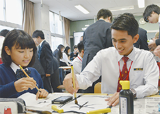 毛筆に挑戦するマレーシアの生徒（右）