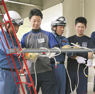 消防団員からロープの結び方を習う参加者