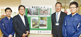 掲示板を囲む小倉社長（左から２人目）と嶋田校長（右隣）、同社スタッフ