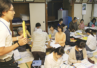永田町上第三町内会の住民にガイドの内容を説明する区職員（左）