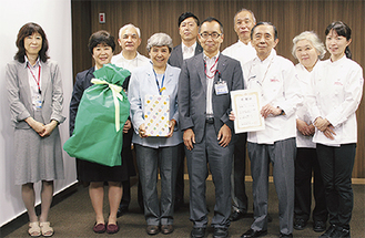 玩具を受け取った濱田理事長（前列左から3人目）、大木節裕区長（同4人目）と洋菓子店主ら