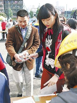 中国語の窓口に保護者を案内する児童（右）