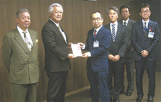 土志田会長（中央左）が大木区長（同右）に目録を渡した